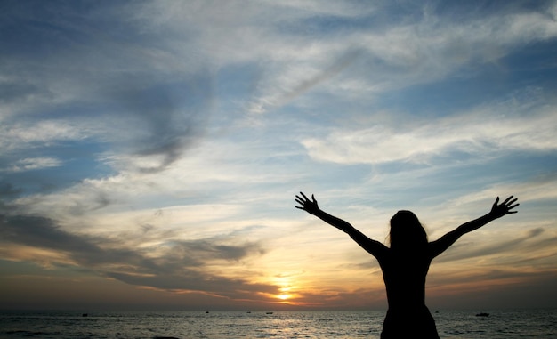 Silhouette de jeune femme debout à la plage