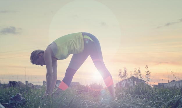 Silhouette jeune femme pratiquant le yoga à l'arrière-cour