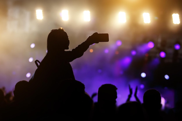 Silhouette de jeune femme prenant une photo de selfie à l'aide de son smartphone