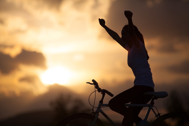 Silhouette d&#39;une jeune fille en VTT