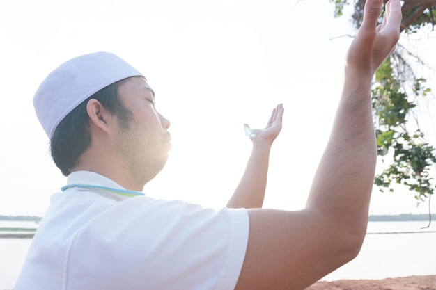 Silhouette Jeune homme musulman asiatique priant au coucher du soleil Concept du festival Ramadan