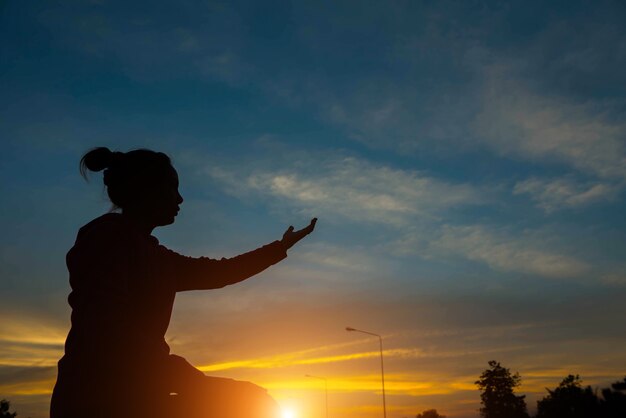 Silhouette de mains de femme avec la lumière du coucher du soleil