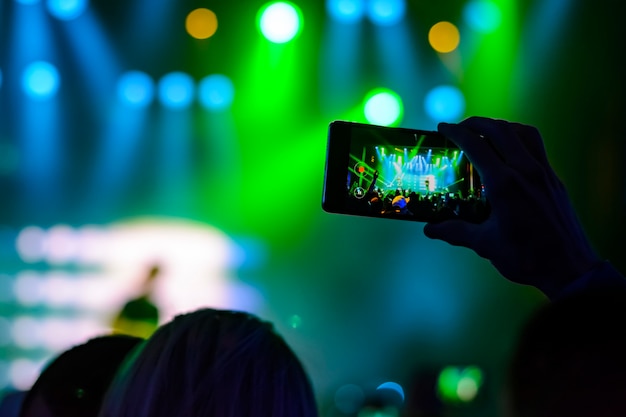 Silhouette des mains avec un smartphone lors d'un concert