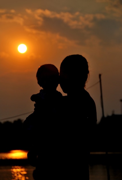 silhouette de la mère et sa fille avec le lever du soleil