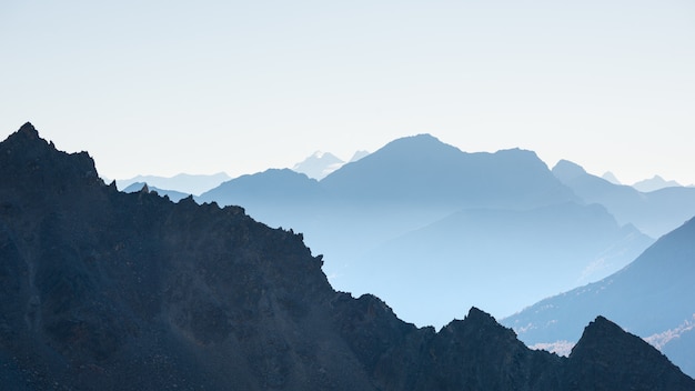 Silhouette de montagne lointaine avec ciel dégagé et lumière douce.