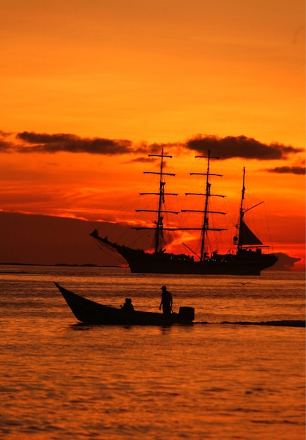 Silhouette d'un navire en mer contre le ciel au coucher du soleil
