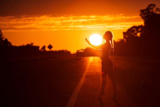 Silhouette noire de jolie fille ou belle femme modèle mince sexy avec des poses de cheveux longs sur la plage de la mer