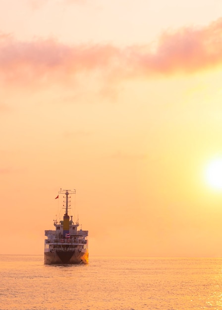 Silhouette Oil Tanker Ship navigue dans la mer avec une belle lumière dorée au coucher du soleil