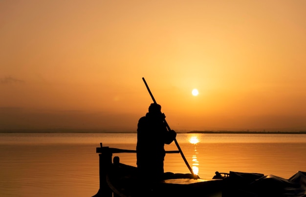 Silhouette d'un pêcheur au coucher du soleil à Albufera Valencia