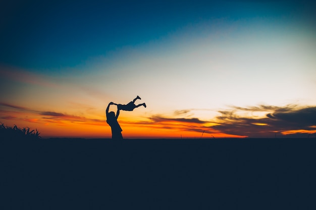 silhouette d&#39;un père et une fille sur un fond de coucher de soleil