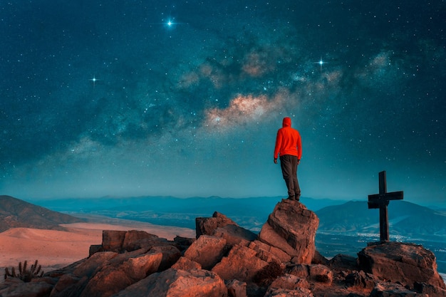 Silhouette d'une personne debout au sommet d'une montagne la nuit sur fond de voie lactéex9