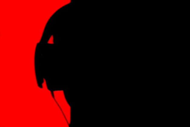 Silhouette d'une personne portant des écouteurs sur un fond rouge