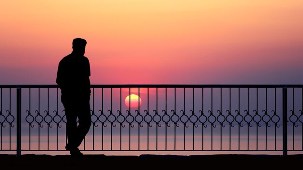 silhouette de personnes au bord de la mer au coucher du soleil