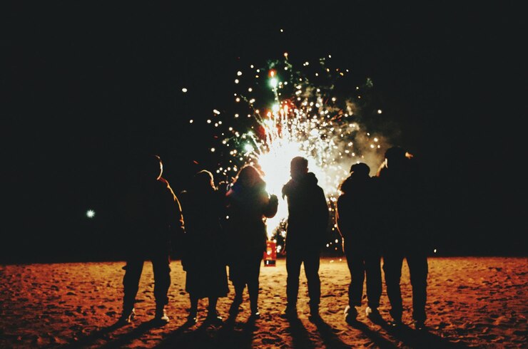 Photo silhouette de personnes debout contre des feux d'artifice éclairés