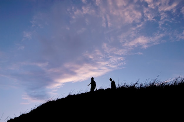 Silhouette de personnes marchant sur la colline à la montagne