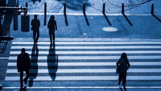 Silhouette personnes marchent sur le passage pour piétons