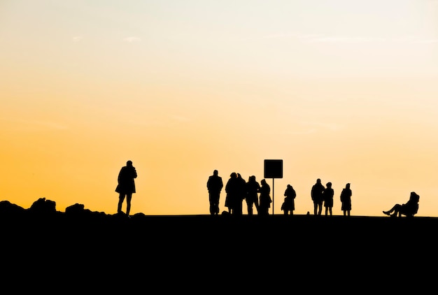 Silhouette de personnes sur la terre contre le ciel au coucher du soleil