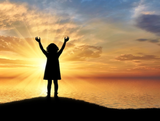 Silhouette, petite fille heureuse debout sur une colline près de la mer sur un fond. Image conceptuelle