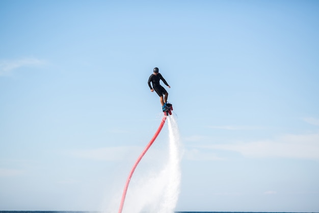 Silhouette d'un pilote de fly board en mer