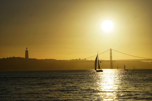 Photo silhouette de pont sur la mer contre le ciel au coucher du soleil