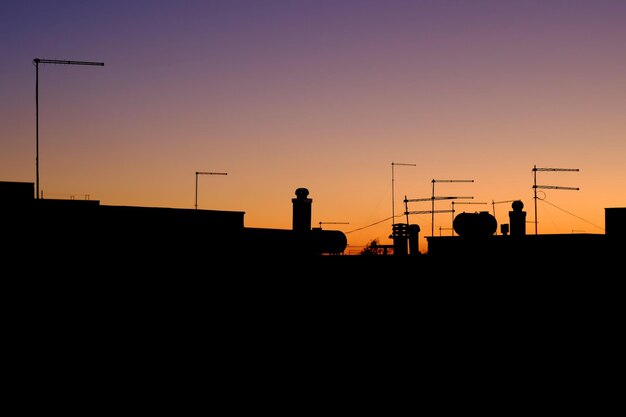 Photo silhouette d'un poteau de téléphone contre le ciel orange