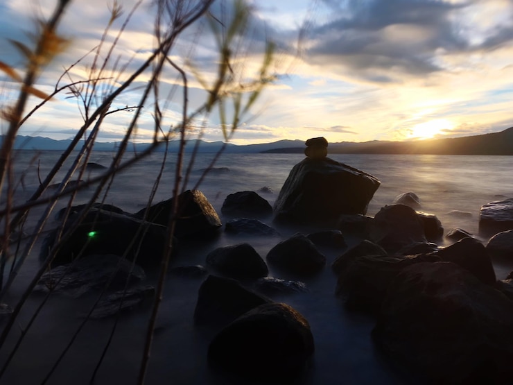 Photo silhouette de rochers sur la plage contre le ciel au coucher du soleil