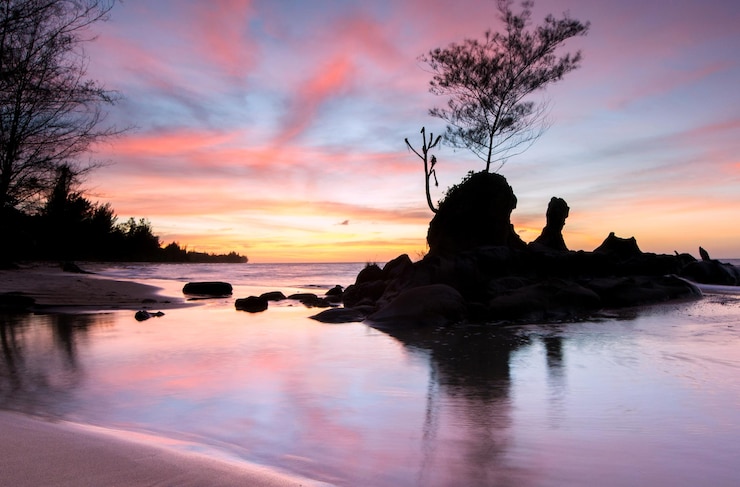 Photo silhouette de roches sur la mer contre le ciel au coucher du soleil