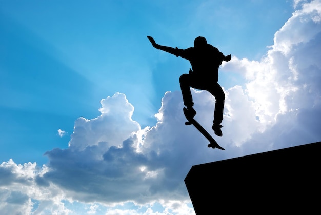 Silhouette de saut de patineur et ciel bleu