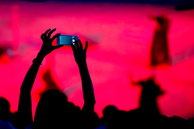 Photo silhouette de smartphone tout en photographiant un spectacle