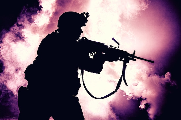 Silhouette de soldat d'infanterie moderne, combattant de l'armée d'élite en munitions tactiques et casque, debout avec un fusil de service d'assaut dans les mains