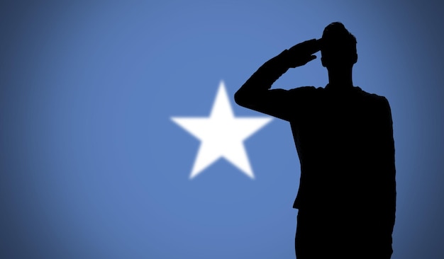 Silhouette d'un soldat saluant contre le drapeau de la somalie