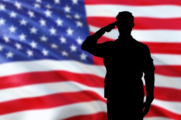 Silhouette de soldats saluant le drapeau des États-Unis pour le jour du souvenir ou le jour des anciens combattants