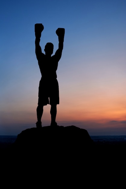 Silhouette sombre du boxeur masculin posant à l&#39;extérieur en été