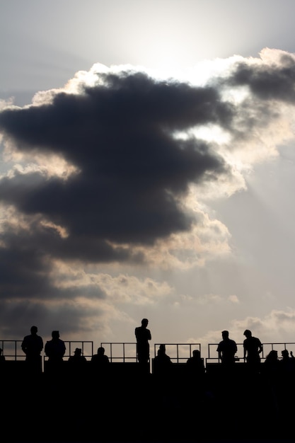 silhouette de spectateurs dans une tribune observant une corrida