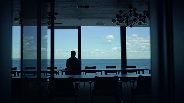 Silhouette de travailleur au repos directeur du bureau de la mer envisageant les problèmes du projet