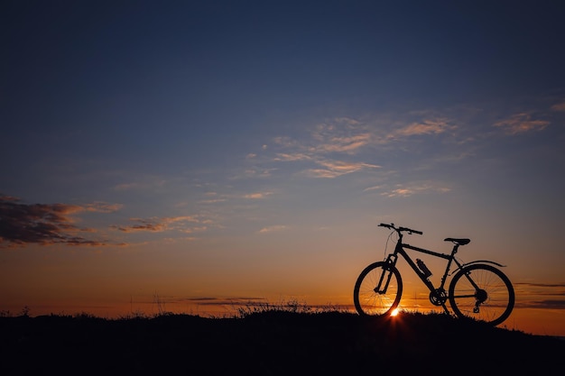 Silhouette d'un vélo sur le ciel coucher de soleil