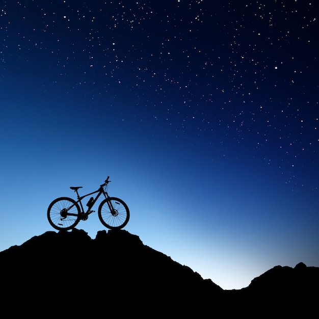 Silhouette de vélo de montagne sur le ciel nocturne