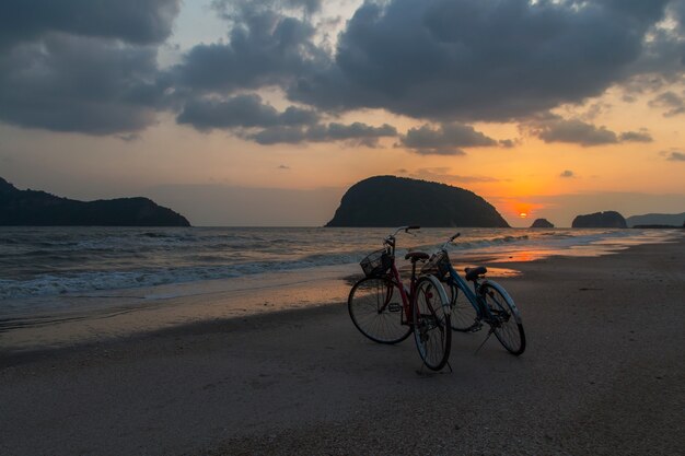 Silhouette de vélo à la plage, vélos sur la plage coucher de soleil ou lever du soleil