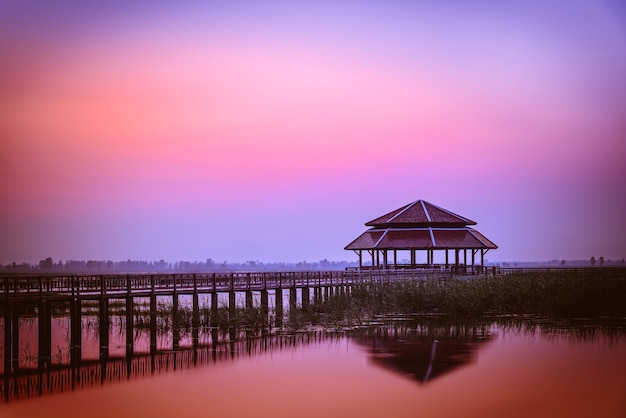 Silhouette vieux pont en bois et pavillon dans le lac au coucher du soleil