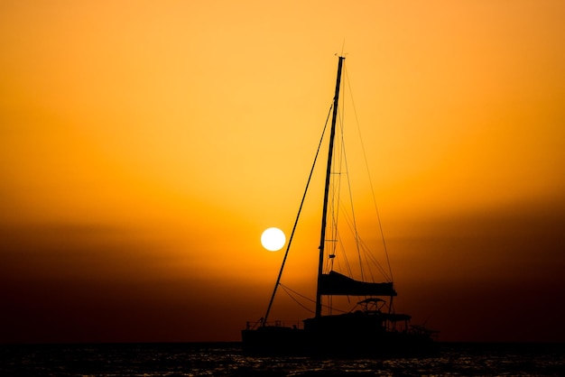 Photo la silhouette d'un voilier au coucher du soleil