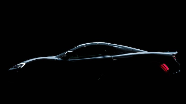 Photo silhouette d'une voiture de sport noire avec des phares sur fond noir