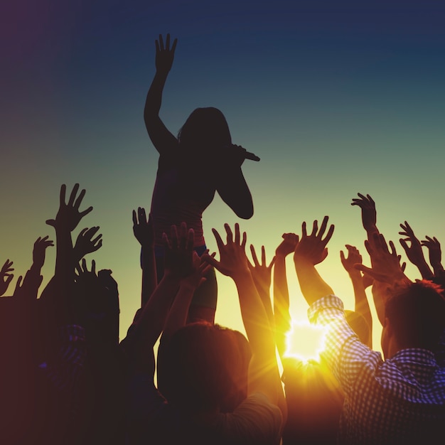 Silhouettes d&#39;un concert de musique au coucher du soleil