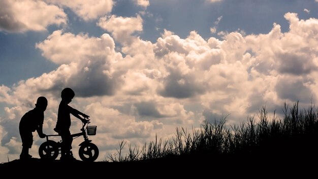 Silhouettes d'enfants jouant avec des amis.