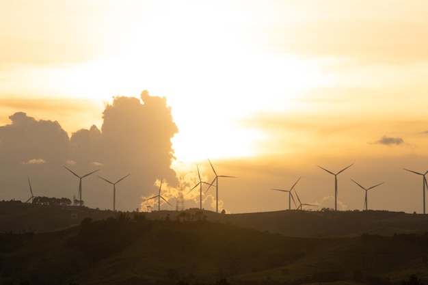 Silhouettes de ferme d'éoliennes sur les montagnes en zone rurale