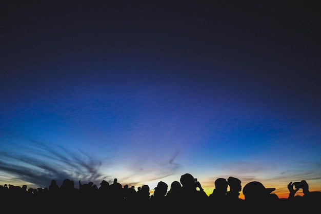 Photo des silhouettes de gens contre le ciel au coucher du soleil