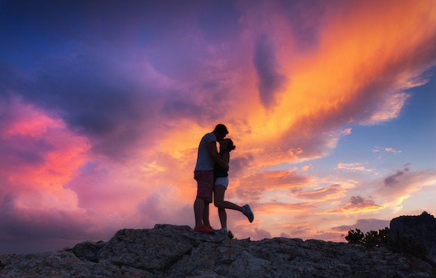 Silhouettes d'un homme étreignant et embrassant et sa petite amie