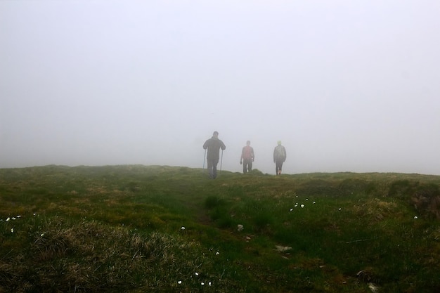 Silhouettes d'hommes dans le brouillard Hommes voyageant en randonnée dans les montagnes