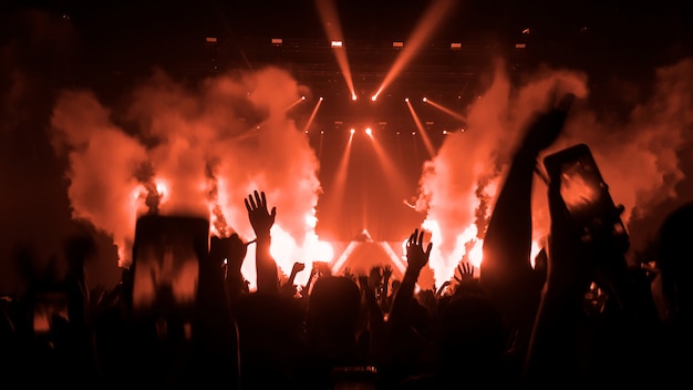 Silhouettes de mains levées dans un concert de musique ou un festival