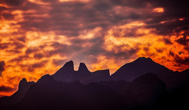 Des silhouettes de montagnes sur un ciel spectaculaire au coucher du soleil