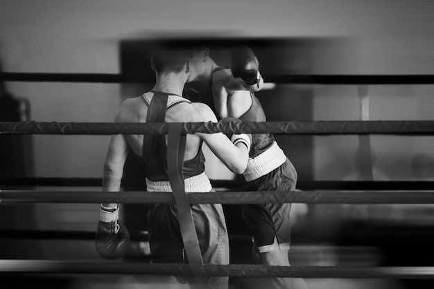 Silhouettes noires et blanches d'athlètes de boxe dans le ring Sports de combat Faible profondeur de champ se concentrer sur les mains des athlètes